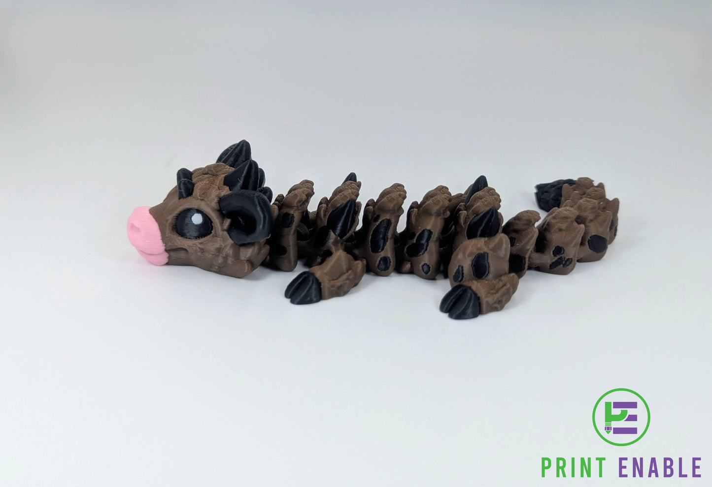 Side profile of articulated Baby Cow Dragon with cow-inspired spotted detailing