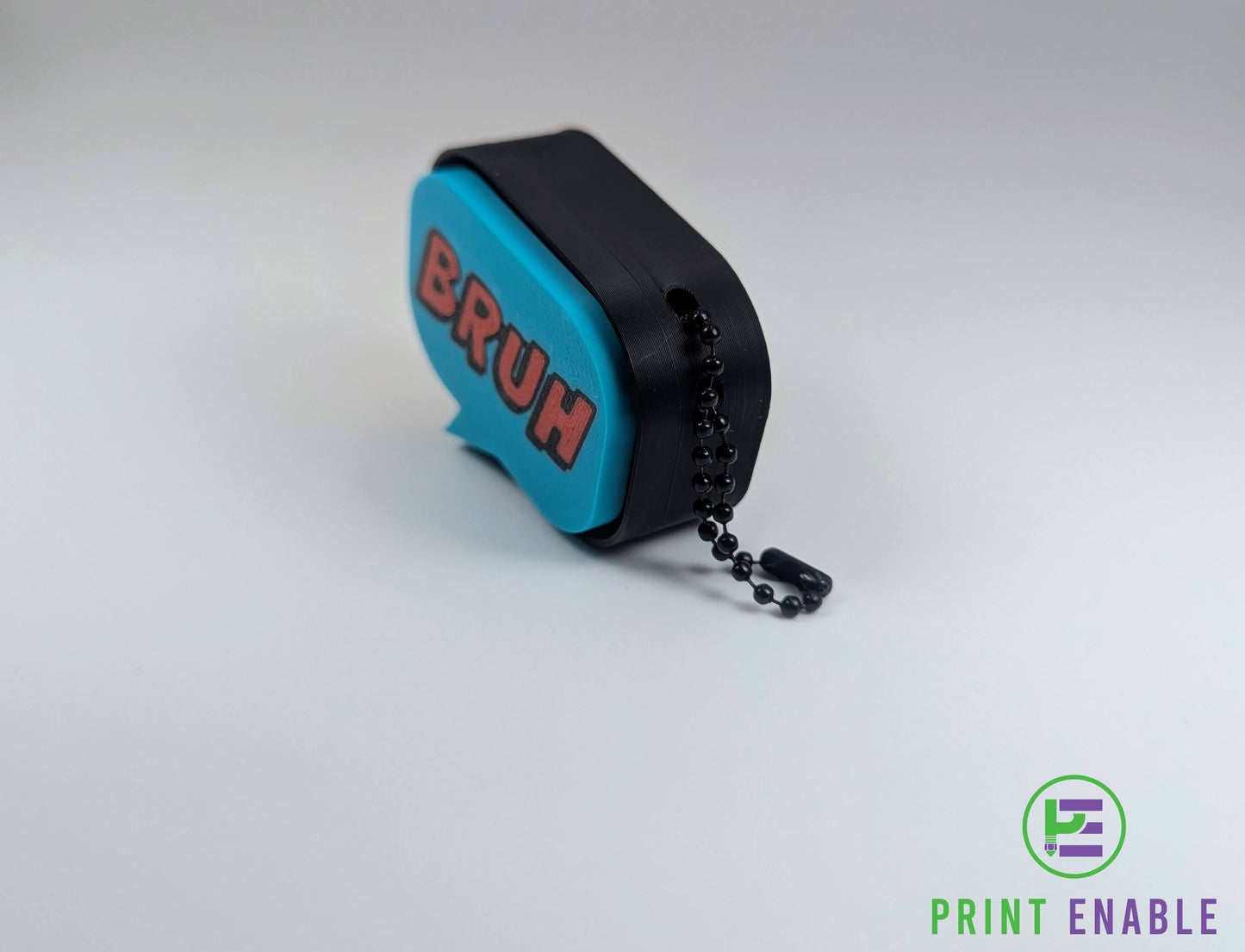 Angled view of Bruh clicker fidget showing 3D printed texture and keychain attachment
