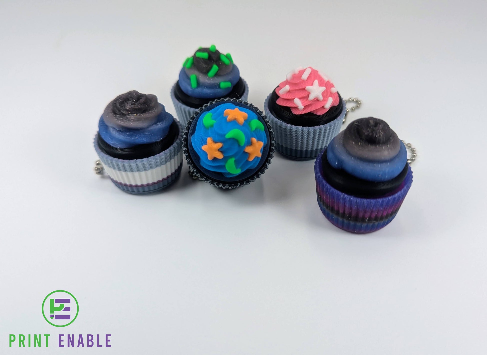 Cupcake clicker fidget keychains in multiple colourful designs with detailed frosting and sprinkles