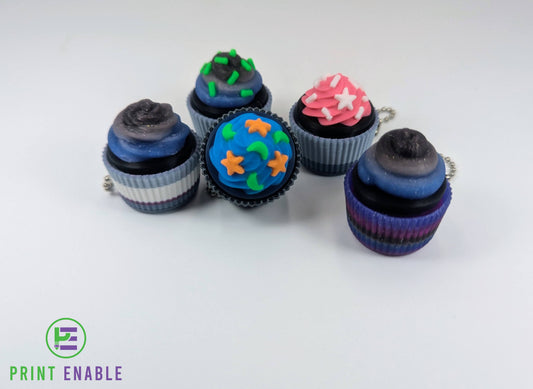 Cupcake clicker fidget keychains in multiple colourful designs with detailed frosting and sprinkles