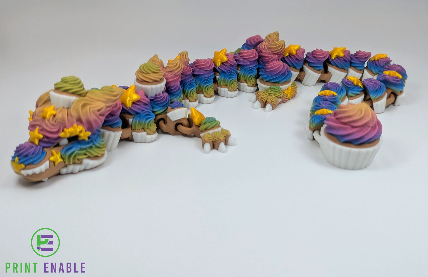 Articulated Cupcake Dragon featuring rainbow frosting details, cupcake scales and golden star accents.